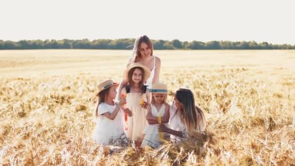Матери с дочерьми в шляпах позируют на пшеничном поле — стоковое видео