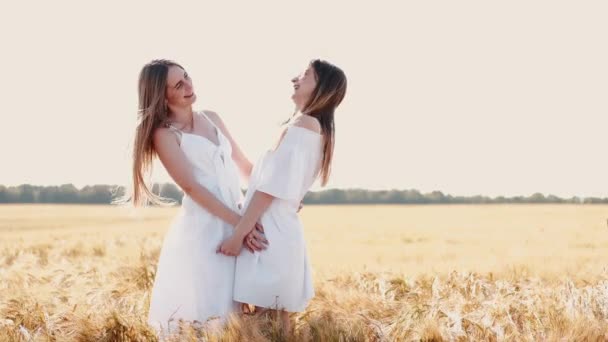 Vrouwen met blond lang haar in witte jurken op het tarweveld — Stockvideo