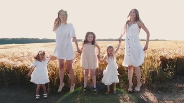 Mädchen in weißen Kleidern halten Händchen und springen auf Pfad — Stockvideo