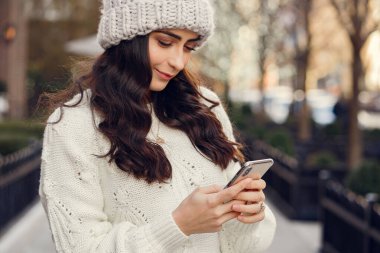 Şehirde beyaz kazak giyen tatlı bir esmer.