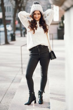 Şehirde beyaz kazak giyen tatlı bir esmer.