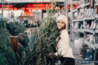 Beyaz süveter ve Noel ağacı içinde tatlı bir esmer.