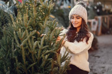Beyaz süveter ve Noel ağacı içinde tatlı bir esmer.