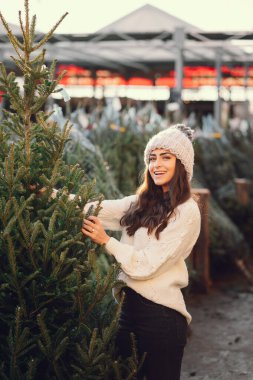 Beyaz süveter ve Noel ağacı içinde tatlı bir esmer.