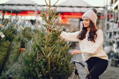Beyaz süveter ve Noel ağacı içinde tatlı bir esmer.