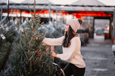 Beyaz süveter ve Noel ağacı içinde tatlı bir esmer.