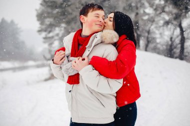 Sevgili çift kış parkında yürüyor.