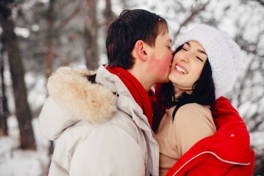 Sevgili çift kış parkında yürüyor.