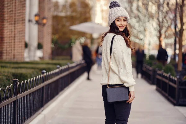 Brune mignonne dans un pull blanc dans une ville — Photo