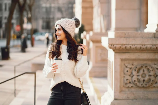 Brune mignonne dans un pull blanc dans une ville — Photo