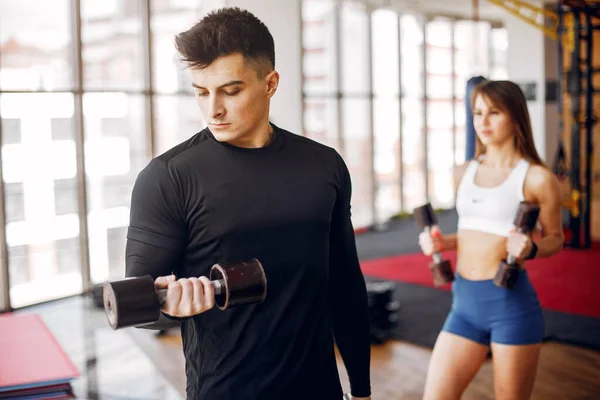 Un beau couple sportif est engagé dans une salle de gym — Photo