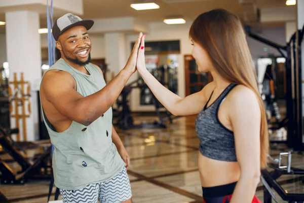 Un beau couple sportif est engagé dans une salle de gym — Photo
