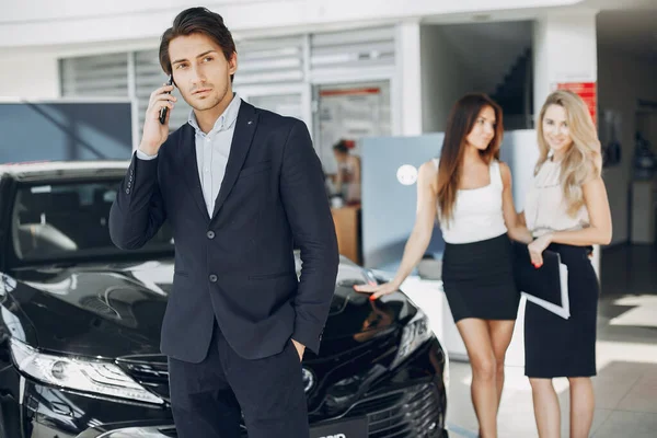 Stylish and elegant people in a car salon