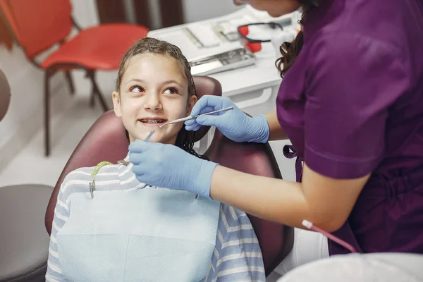 Mooi klein meisje zitten in de tandartsen kantoor — Stockfoto