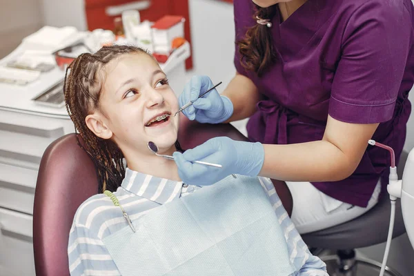 Mooi klein meisje zitten in de tandartsen kantoor — Stockfoto