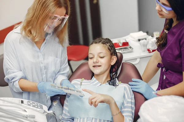 Mooi klein meisje zitten in de tandartsen kantoor — Stockfoto