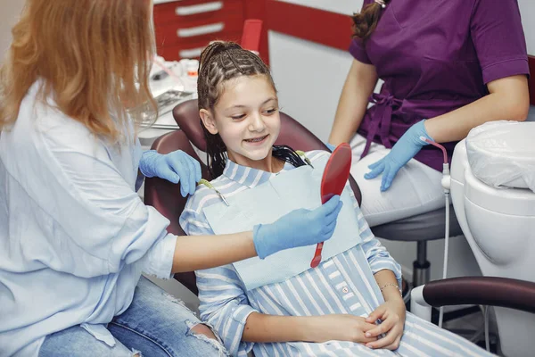 Mooi klein meisje zitten in de tandartsen kantoor — Stockfoto