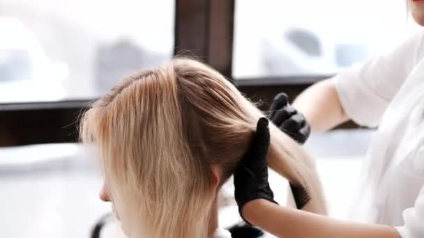 Gros plan du processus de teinture des cheveux par coiffeur dans un salon de beauté — Video