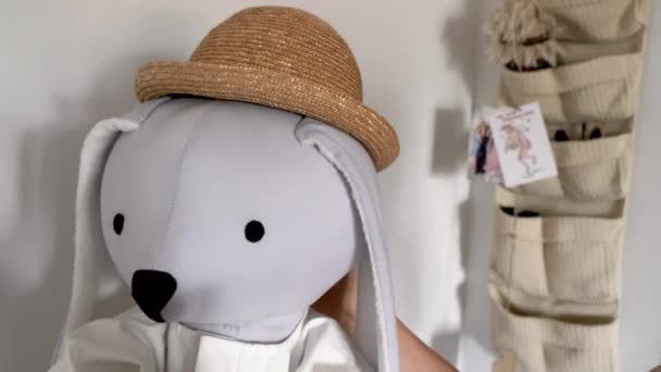 Великий кролик ручної роботи в солом'яному капелюсі в білій кімнаті — стокове відео