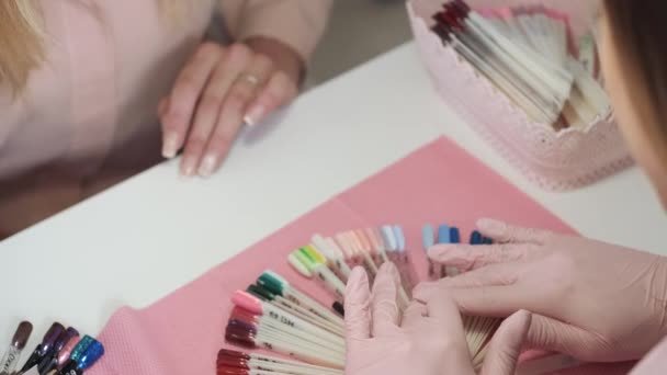 Client choosing colors for doing manicure in beauty salon — Stock Video