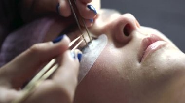 Profesyonel güzellik salonunda kirpik uzatma prosedürü uyguluyor