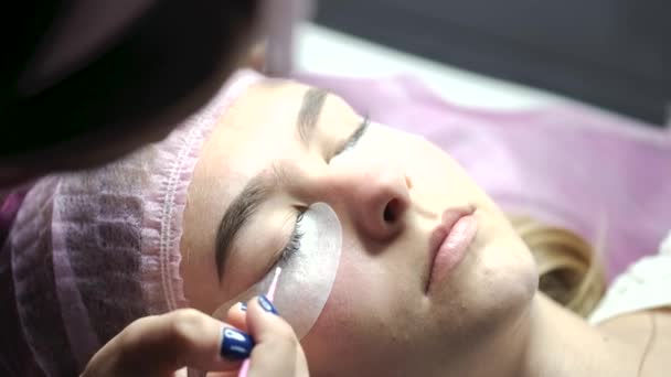 Szakmai teszi szempilla kiterjesztése eljárás szépségszalonban — Stock videók