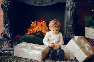 Noel süslemelerinin yanında küçük bir çocuk var.