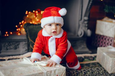 Noel süslemelerinin yanında küçük bir çocuk var.