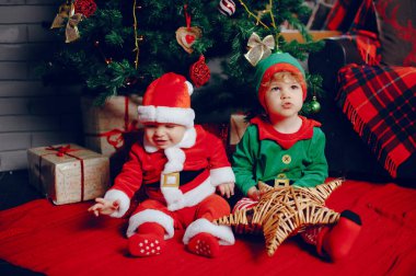 Noel süslemelerinin yakınındaki evde küçük kardeşler kesiliyor.