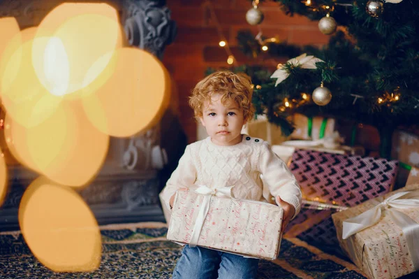Cutte mały chłopiec w domu w pobliżu dekoracji świątecznych — Zdjęcie stockowe