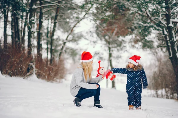 Menina com a mãe brincando em um parque de inverno — Fotografia de Stock