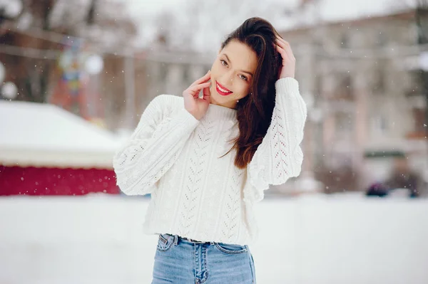 Jovem com uma camisola branca em pé em um parque de inverno — Fotografia de Stock