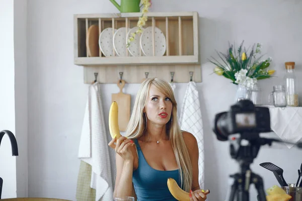 Beautiful and sporty girl in a kitchen recording a video — Stock Photo, Image
