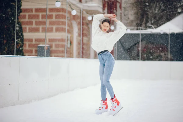 Menina bonito e bonito em uma camisola branca em uma cidade de inverno — Fotografia de Stock