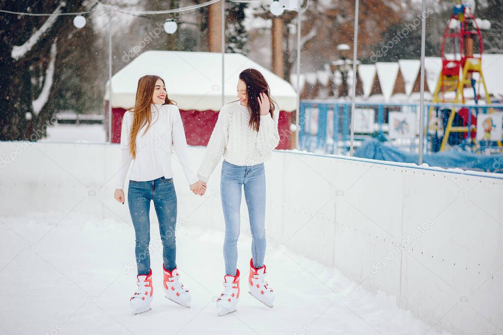 Cute and beautiful girls in a white sweater in a winter city