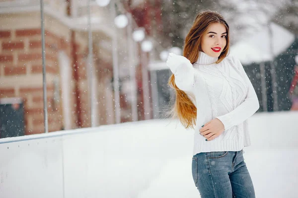 Fiatal lány fehér pulóverben áll a téli parkban — Stock Fotó