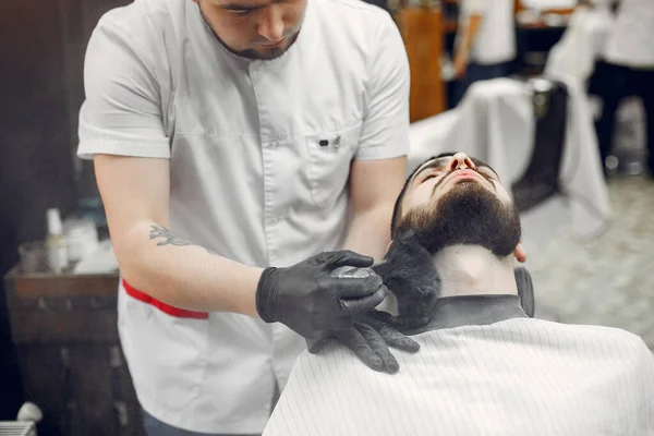 Elegante hombre sentado en una barbería — Foto de Stock