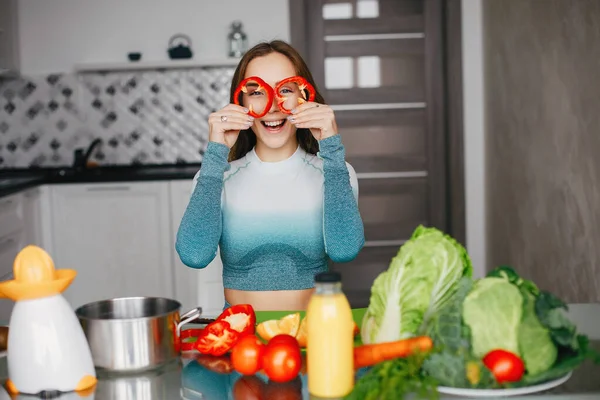 Sport meisje in een keuken met groenten — Stockfoto