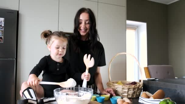 Mãe e filha em camisetas pretas amassando massa na cozinha — Vídeo de Stock