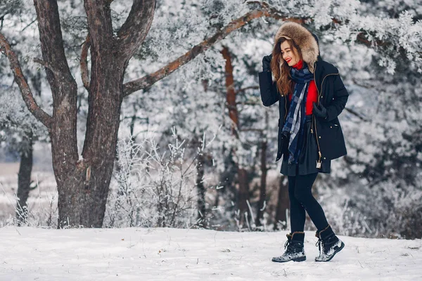 Елегантна і молода дівчина в зимовому парку — стокове фото