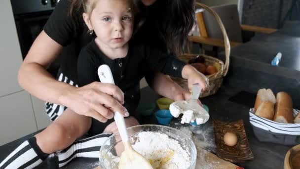 Mutter und kleines Mädchen kneten Teig in moderner Küche — Stockvideo