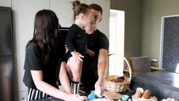 Casal com pequena filha preparando cupcakes na cozinha moderna — Vídeo de Stock