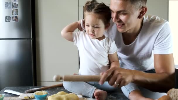 Father and daughter in white T-shirts cooking in modern kitchen. — ストック動画