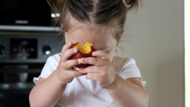 Porträtt av liten flicka som håller frukt i modernt kök — Stockvideo