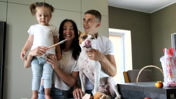 Familia con perro enorme preparando comida en cocina moderna — Vídeo de stock