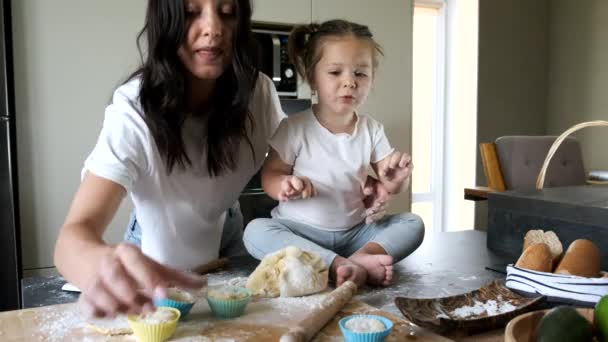Πορτρέτο μητέρας και κόρης ζυμώνοντας ζύμη για cupcakes στην κουζίνα — Αρχείο Βίντεο