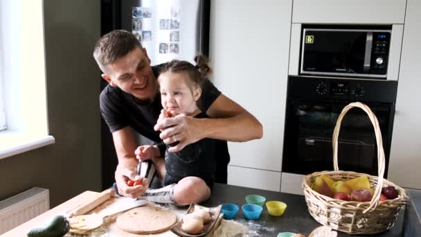 Padre y niña en camisetas negras cocinando en la cocina — Vídeo de stock