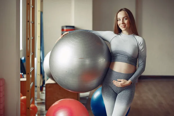 Mujer embarazada entrenando en un gimnasio —  Fotos de Stock