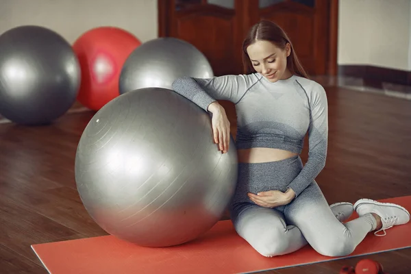 Mujer embarazada entrenando en un gimnasio —  Fotos de Stock
