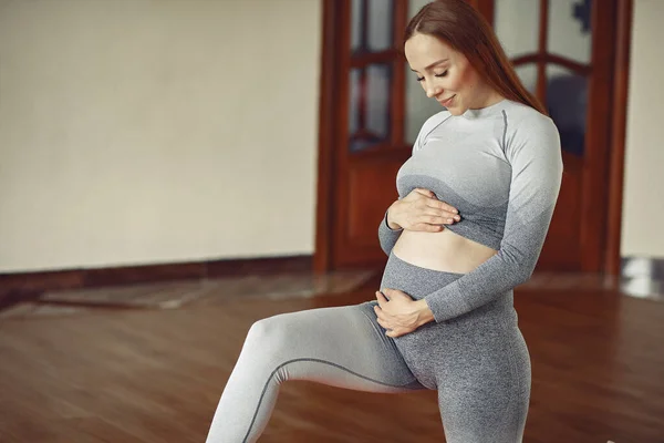 Femeie gravidă de formare într-o sală de gimnastică — Fotografie, imagine de stoc